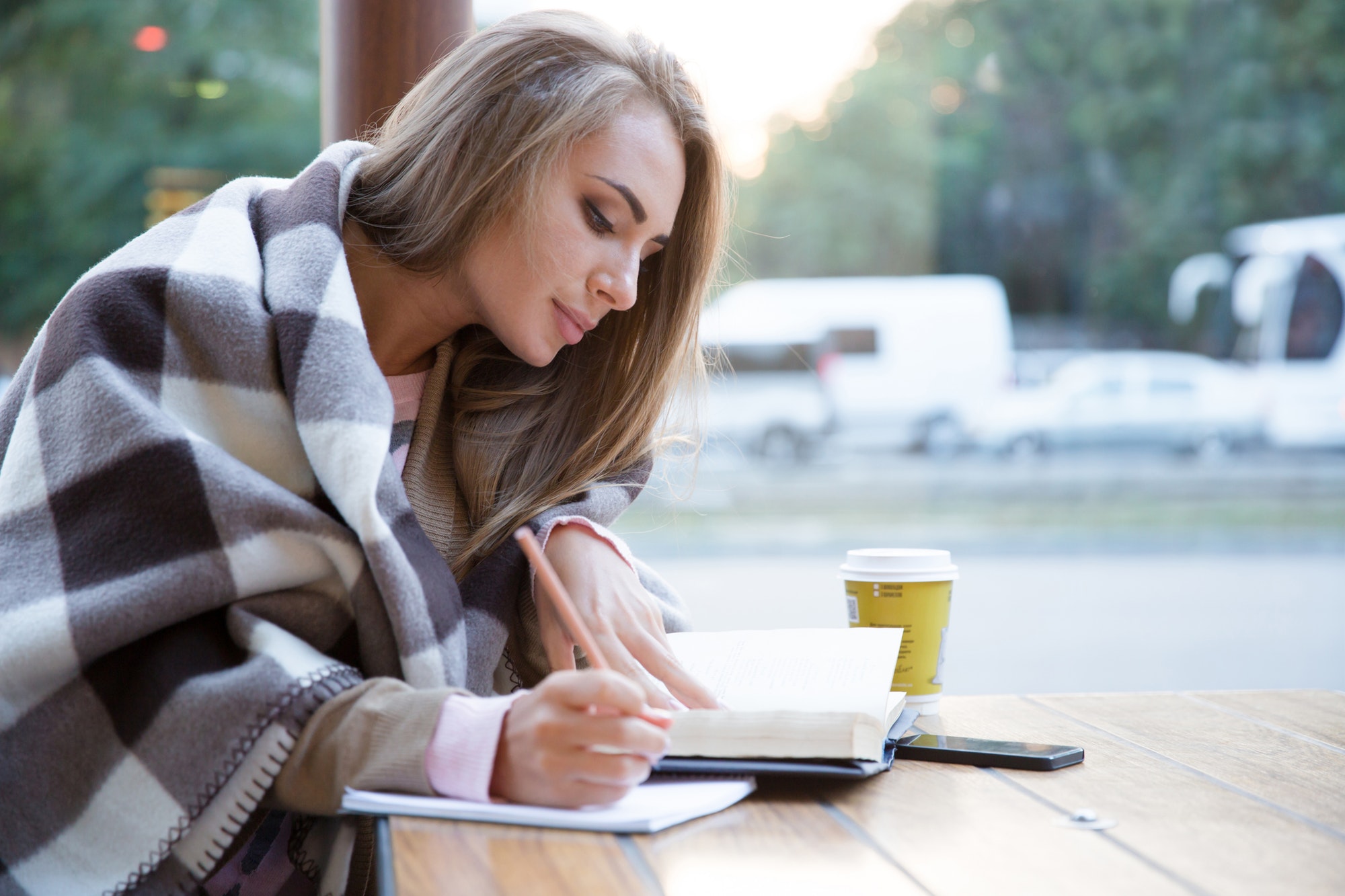 Girl doing homework in cafe