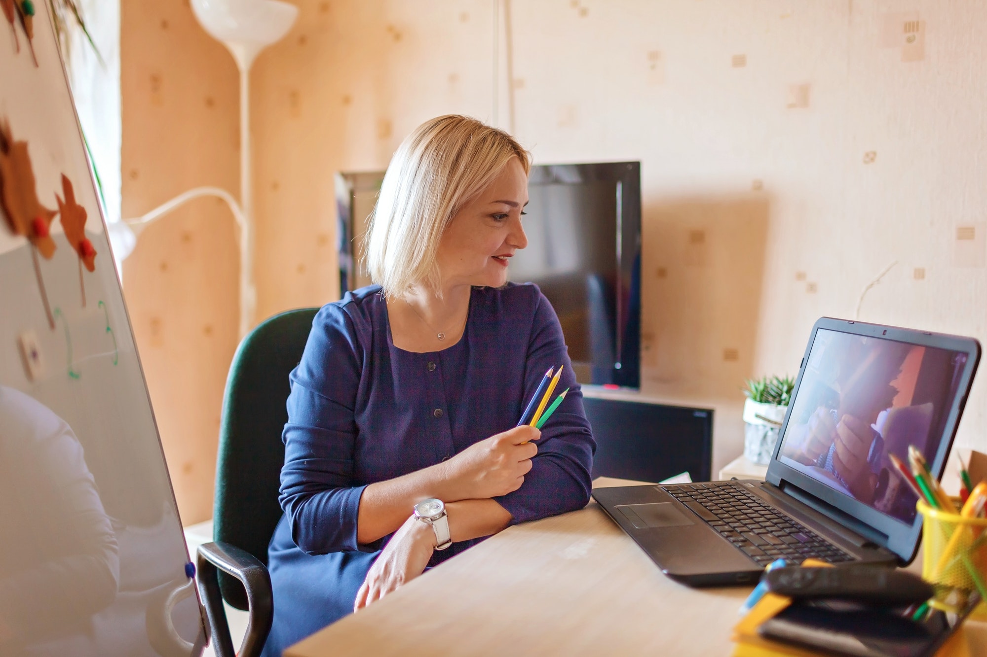 Distant education. Middle aged teacher giving online lesson via internet at home