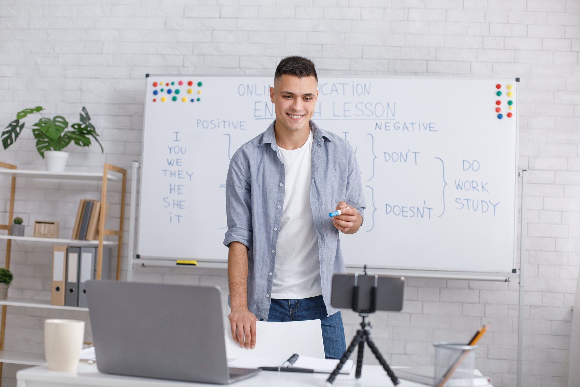 Explaining grammar rules of english grammar online. Smiling man looks at camera and communicates with