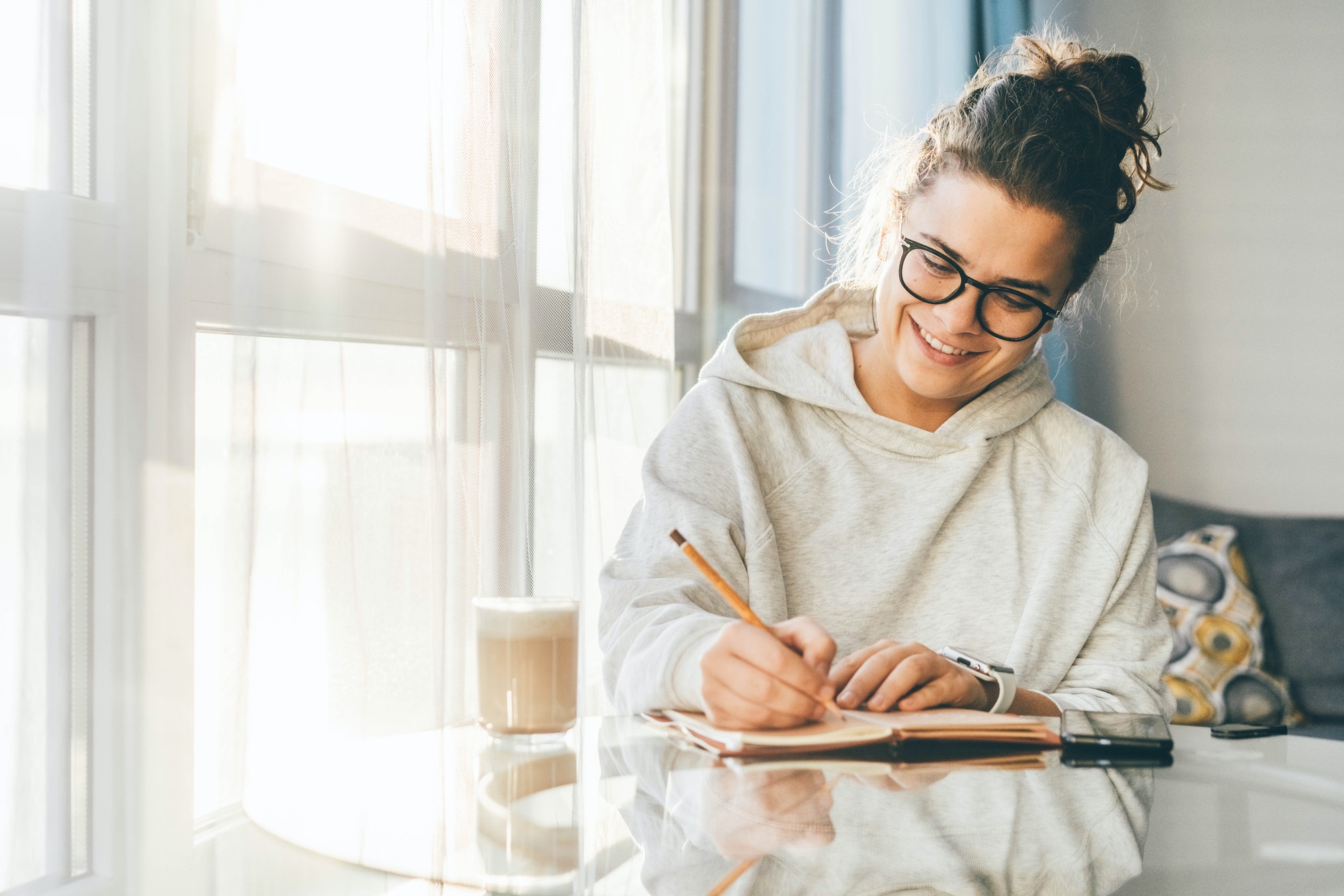 Woman writing notes in paper notebook.