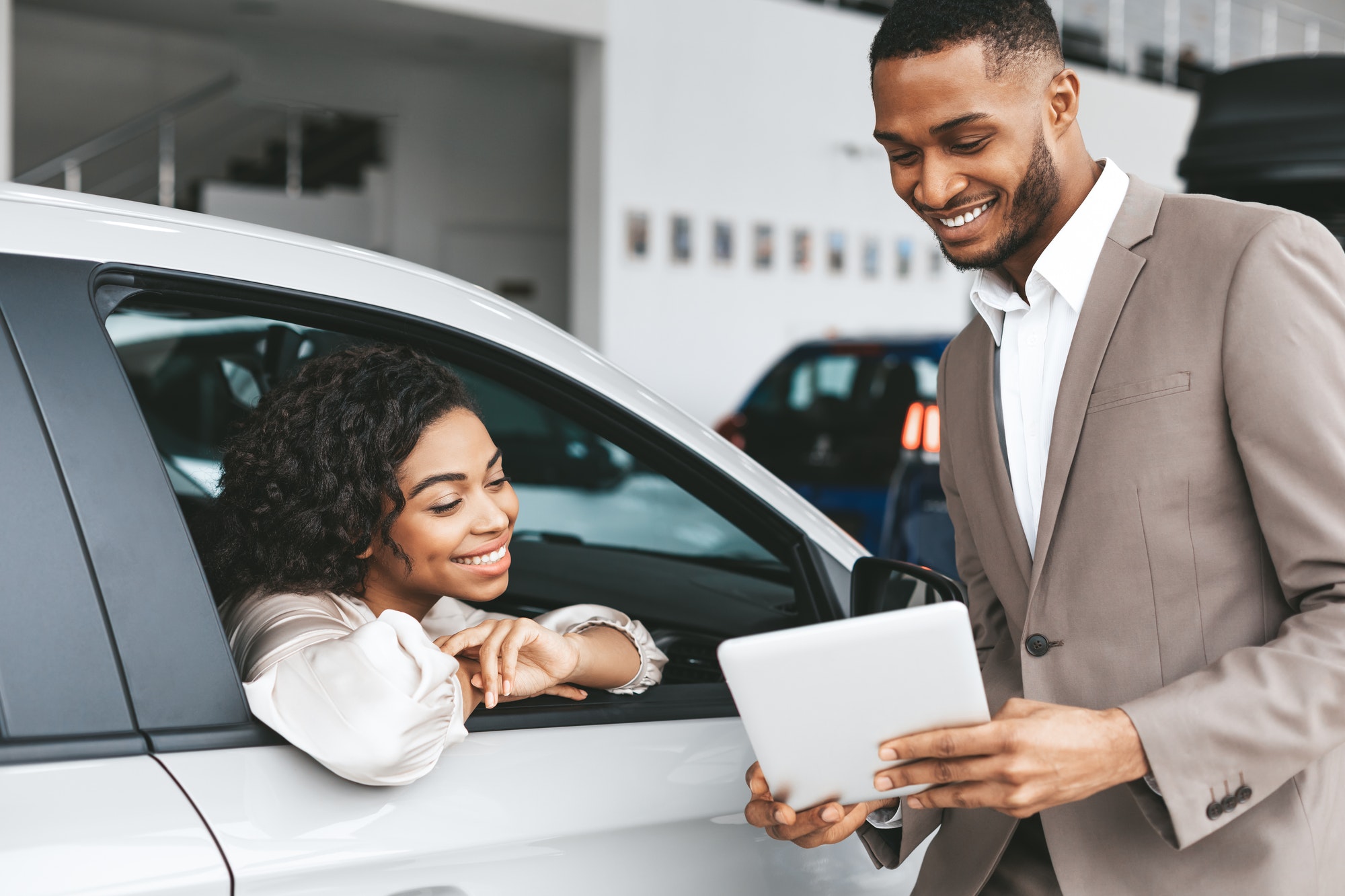 African American Woman Buying Car In Auto Dealership Center
