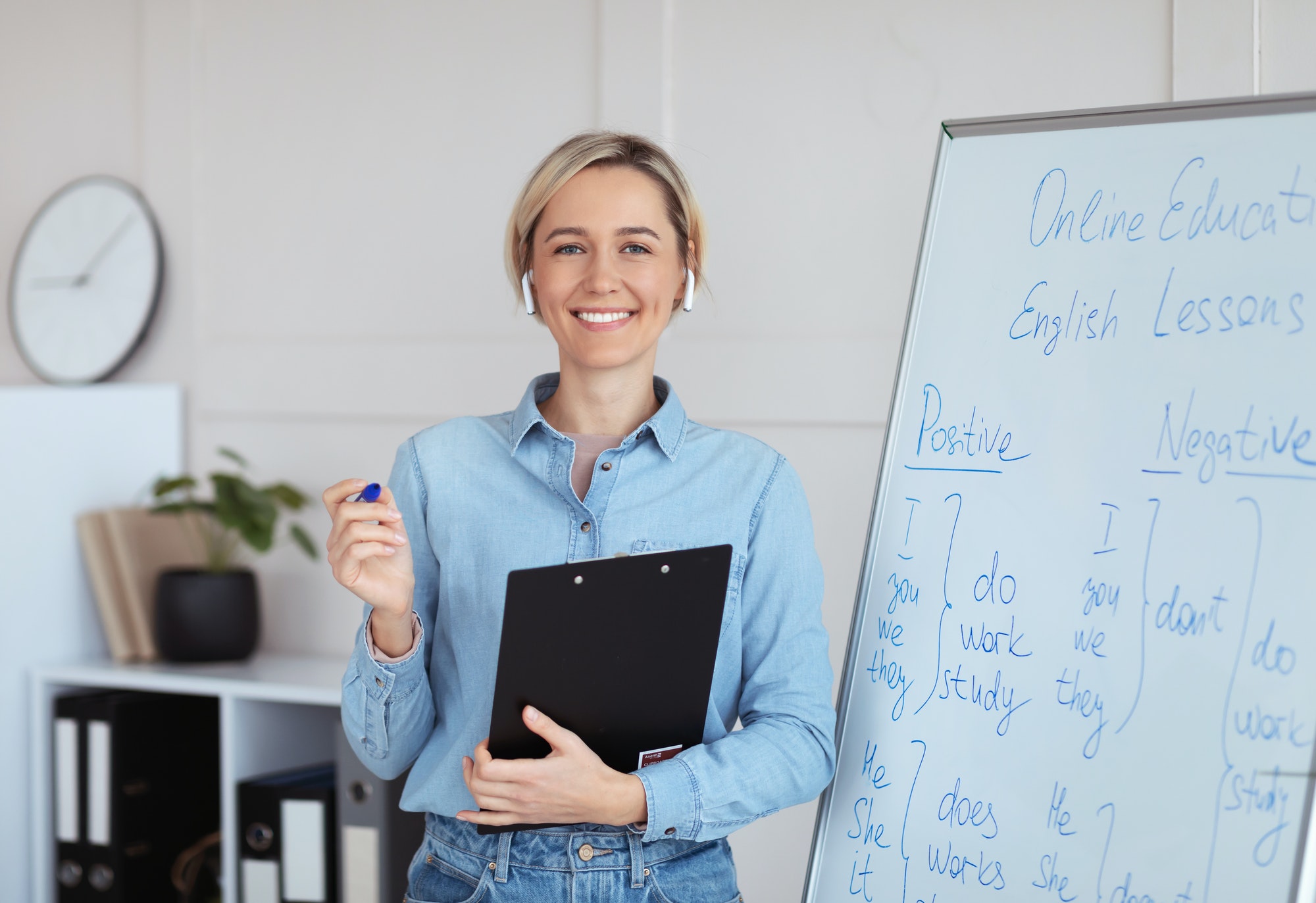 Portrait of happy young English tutor looking at camera and smiling, giving online lesson from home