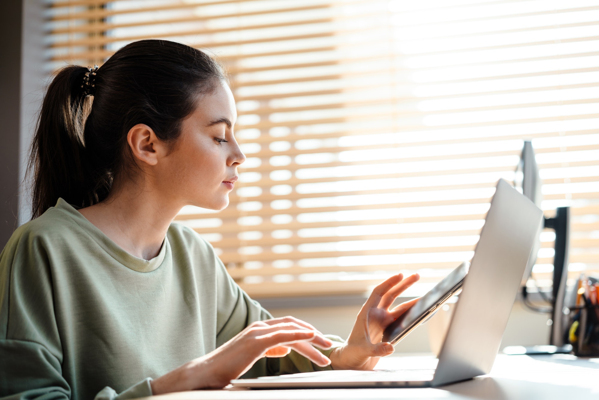 Young brunette woman studying on laptop computer