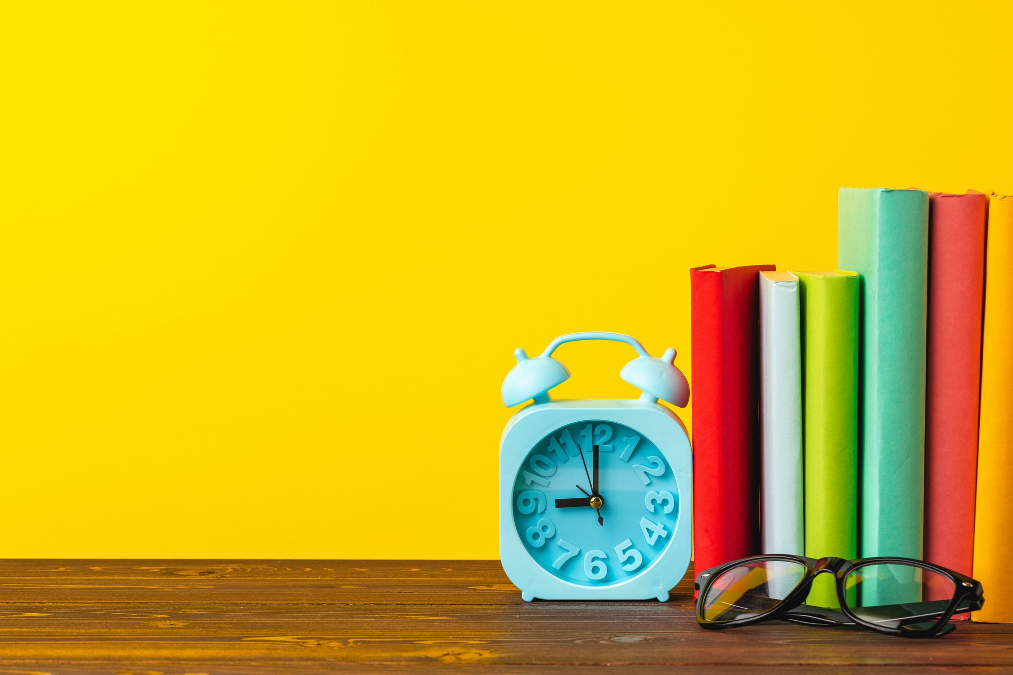 Books and alarm clock on table, education concept